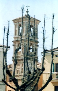Torre intravista dietro ai rami di un albero spoglio